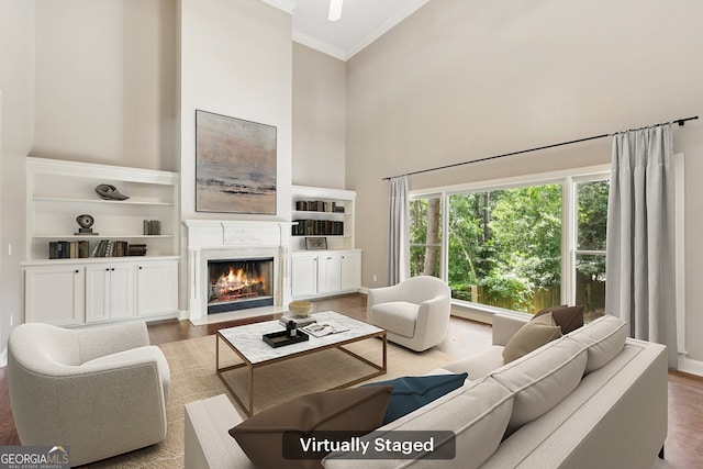 4685 Braselton Hwy, Hoschton, GA 30548 - living room with a towering ceiling, ornamental molding, wood finished floors, a fireplace with flush hearth, and built in features