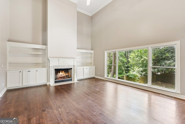 4685 Braselton Hwy, Hoschton, GA 30548 - unfurnished living room featuring a towering ceiling, ornamental molding, a premium fireplace, and dark wood-style flooring