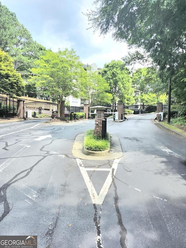 4250 River Green Dr NW Apt 405, Atlanta, GA 30327 - view of asphalt road with a gate, a gated entry, and curbs