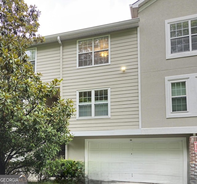 4250 River Green Dr NW Apt 405, Atlanta, GA 30327 - view of home's exterior with an attached garage and stucco siding