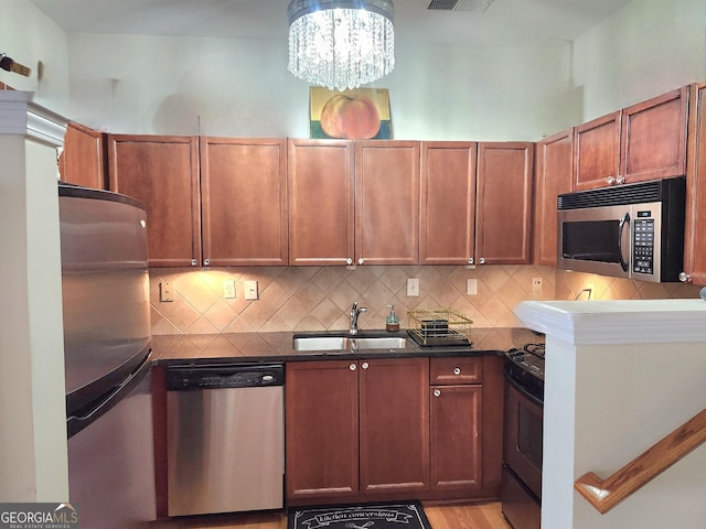 4250 River Green Dr NW Apt 405, Atlanta, GA 30327 - kitchen featuring stainless steel appliances, decorative backsplash, light wood finished floors, and a chandelier