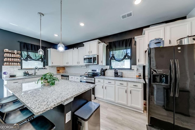 191 Eagle Heights Dr, Maysville, GA 30558 - kitchen with appliances with stainless steel finishes, a kitchen breakfast bar, white cabinets, decorative backsplash, and recessed lighting