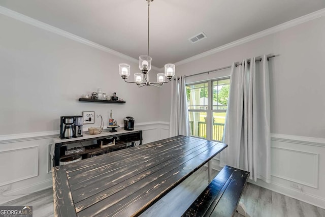 191 Eagle Heights Dr, Maysville, GA 30558 - dining space featuring light wood-style flooring, a wainscoted wall, crown molding, a decorative wall, and a chandelier