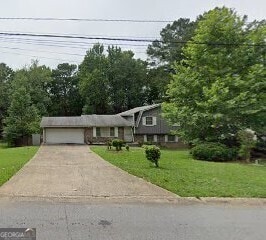 7313 Grayson Dr, Riverdale, GA 30296 - tri-level home with a garage, a front yard, and concrete driveway