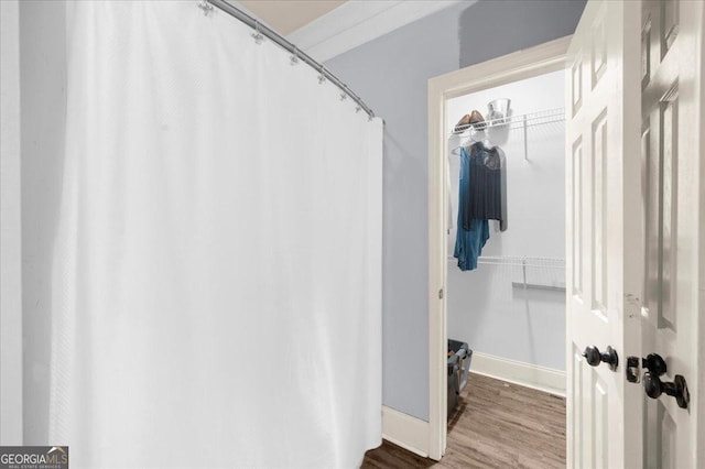 79 Hampton Hills Ln, Cleveland, GA 30528 - bathroom featuring wood finished floors, a spacious closet, and a shower with shower curtain