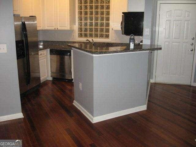 10 Perimeter Summit Blvd NE Unit 3105, Atlanta, GA 30319 - kitchen with dishwashing machine, stainless steel fridge with ice dispenser, dark wood finished floors, white cabinets, and dark stone countertops
