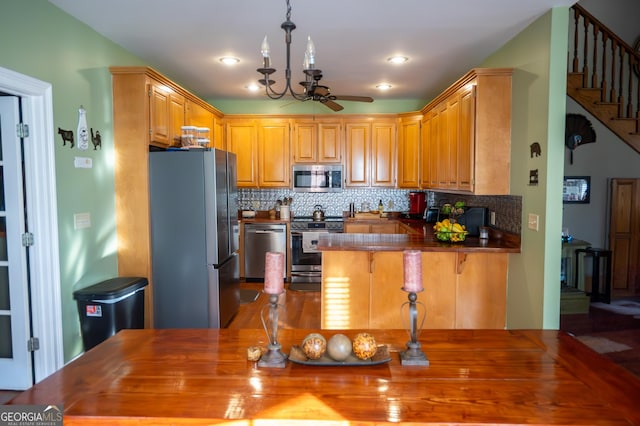 1940 Horne Rd, Eastman, GA 31023 - kitchen featuring appliances with stainless steel finishes, a peninsula, a ceiling fan, backsplash, and dark countertops