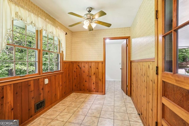 415 Haven Ln, Marietta, GA 30066 - unfurnished room with a wainscoted wall, a ceiling fan, wooden walls, wallpapered walls, and light tile patterned floors