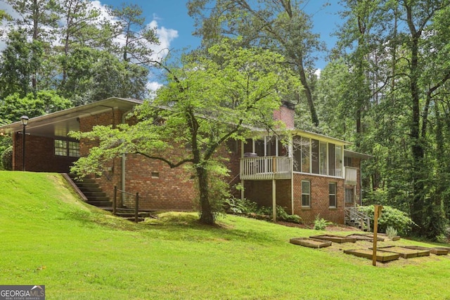 415 Haven Ln, Marietta, GA 30066 - back of property with brick siding, a sunroom, a yard, a garden, and a chimney
