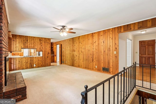 415 Haven Ln, Marietta, GA 30066 - unfurnished living room with ceiling fan, wooden walls, carpet floors, and ornamental molding
