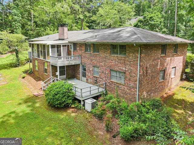 415 Haven Ln, Marietta, GA 30066 - back of house featuring a sunroom, a deck, a chimney, a lawn, and brick siding
