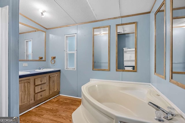 203 Shaw St, Rincon, GA 31326 - bathroom with wood finished floors, double vanity, a garden tub, ornamental molding, and a textured ceiling