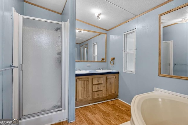 203 Shaw St, Rincon, GA 31326 - bathroom featuring a shower stall, ornamental molding, wood finished floors, double vanity, and a textured ceiling