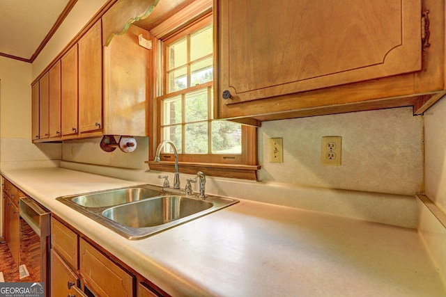 5739 Cobb Mdw, Norcross, GA 30093 - kitchen featuring dishwashing machine, ornamental molding, brown cabinets, and light countertops