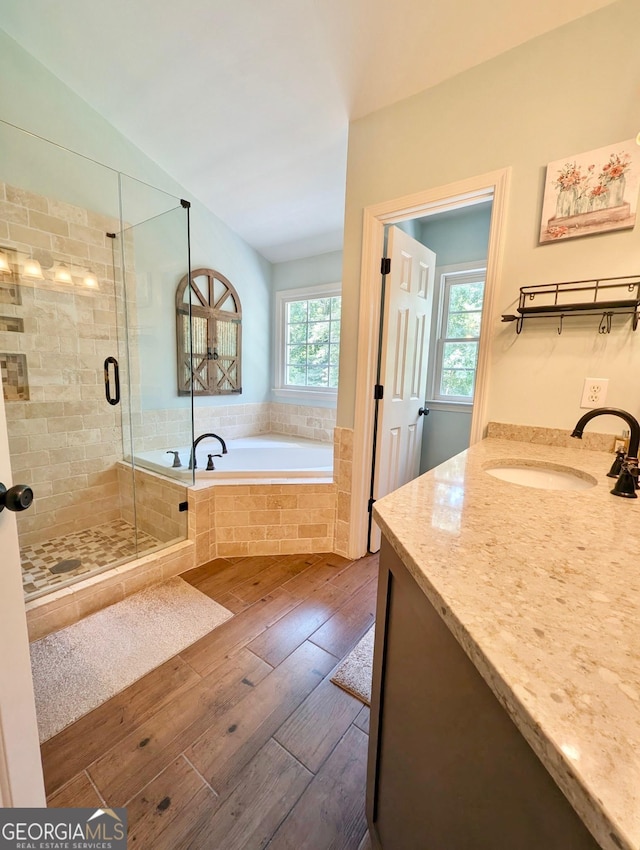 1581 Shetland Pony Ct NW, Suwanee, GA 30024 - bathroom with hardwood / wood-style flooring, a garden tub, vanity, a shower stall, and lofted ceiling