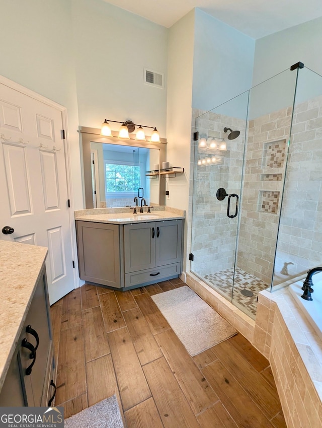 1581 Shetland Pony Ct NW, Suwanee, GA 30024 - bathroom with wood tiled floors, vanity, a shower stall, and a garden tub