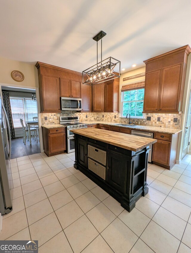 1581 Shetland Pony Ct NW, Suwanee, GA 30024 - kitchen with appliances with stainless steel finishes, butcher block countertops, backsplash, and light tile patterned floors