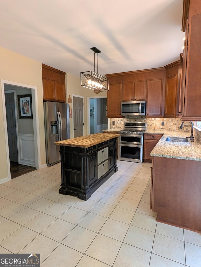 1581 Shetland Pony Ct NW, Suwanee, GA 30024 - kitchen with stainless steel appliances, butcher block countertops, decorative backsplash, and light tile patterned floors