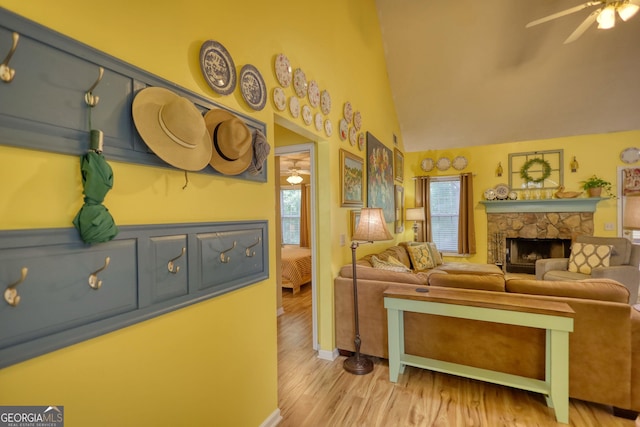 1248 Rockview Ct, Loganville, GA 30052 - living room with a ceiling fan, a stone fireplace, lofted ceiling, and wood finished floors