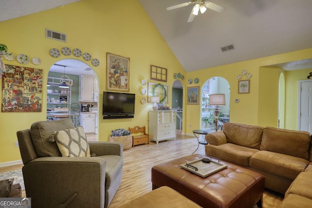 1248 Rockview Ct, Loganville, GA 30052 - living room featuring high vaulted ceiling, arched walkways, a ceiling fan, and light wood finished floors