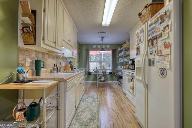 1248 Rockview Ct, Loganville, GA 30052 - kitchen with white appliances, light countertops, a textured ceiling, light wood finished floors, and backsplash