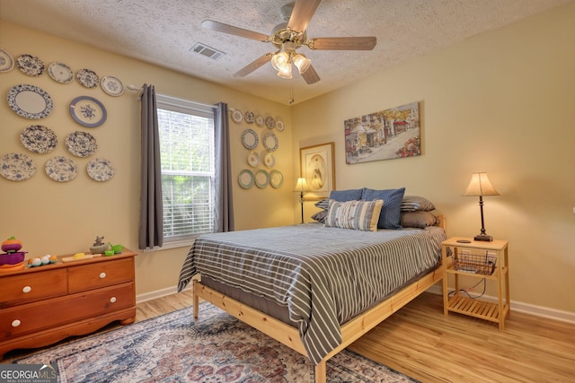 1248 Rockview Ct, Loganville, GA 30052 - bedroom featuring wood finished floors, a textured ceiling, and a ceiling fan