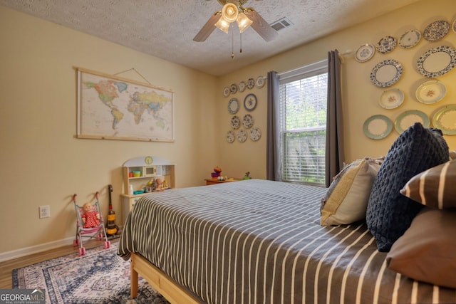 1248 Rockview Ct, Loganville, GA 30052 - bedroom with wood finished floors, a textured ceiling, and ceiling fan