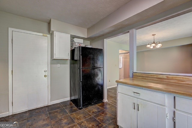 5026 Brittany Dr, Stone Mountain, GA 30083 - kitchen with freestanding refrigerator, white cabinetry, a chandelier, and decorative light fixtures