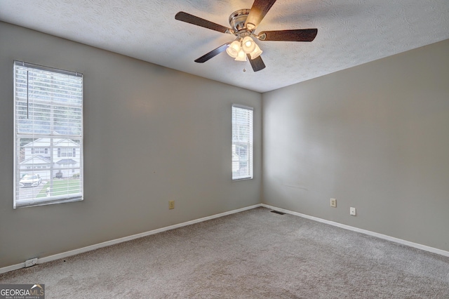 5026 Brittany Dr, Stone Mountain, GA 30083 - unfurnished room with healthy amount of natural light, a textured ceiling, ceiling fan, and carpet flooring