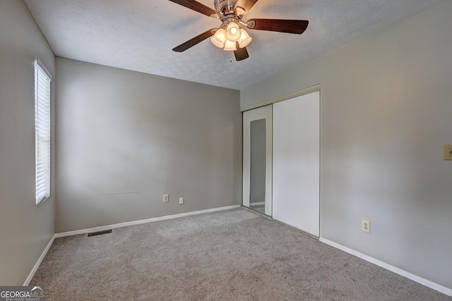 5026 Brittany Dr, Stone Mountain, GA 30083 - unfurnished bedroom with a textured ceiling, carpet flooring, a closet, and ceiling fan