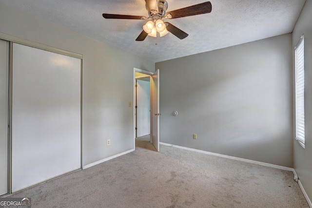 5026 Brittany Dr, Stone Mountain, GA 30083 - unfurnished bedroom featuring carpet flooring, a closet, a textured ceiling, and ceiling fan