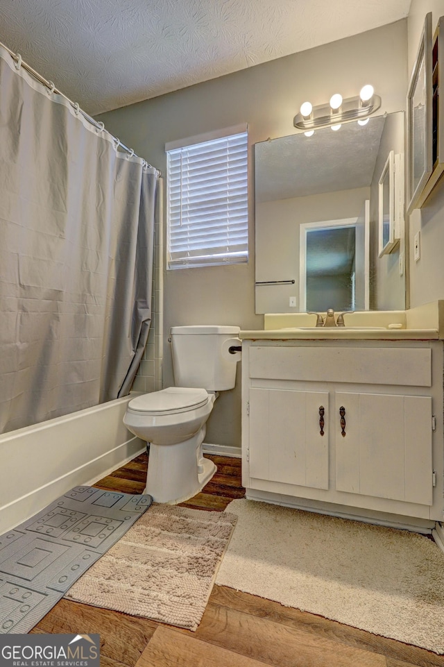 5026 Brittany Dr, Stone Mountain, GA 30083 - full bath with vanity, shower / bath combo with shower curtain, wood finished floors, and a textured ceiling