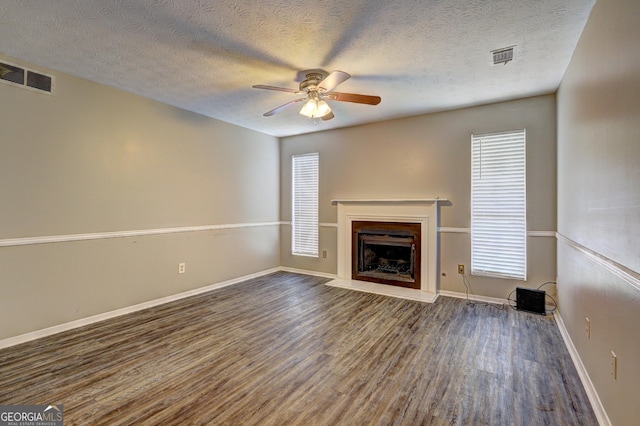 5026 Brittany Dr, Stone Mountain, GA 30083 - unfurnished living room with wood finished floors, ceiling fan, a fireplace, and a textured ceiling