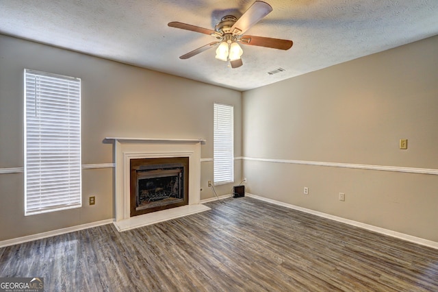 5026 Brittany Dr, Stone Mountain, GA 30083 - unfurnished living room with wood finished floors, a ceiling fan, a textured ceiling, and a fireplace with raised hearth
