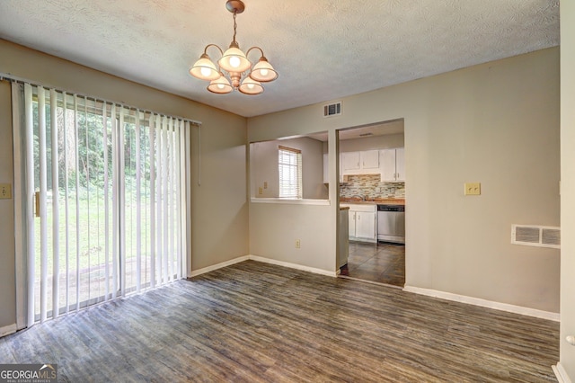 5026 Brittany Dr, Stone Mountain, GA 30083 - spare room with a chandelier, dark wood-style flooring, and a textured ceiling