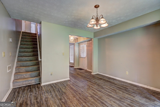 5026 Brittany Dr, Stone Mountain, GA 30083 - spare room featuring wood finished floors, a chandelier, stairs, and a textured ceiling