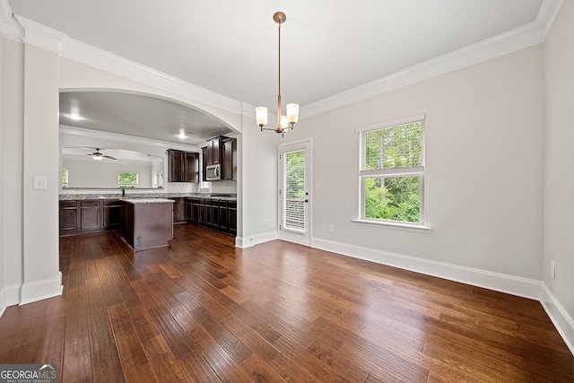 3865 Rifflepool Ct, Douglasville, GA 30135 - kitchen featuring light countertops, dark brown cabinets, dark wood-style flooring, ornamental molding, and a center island