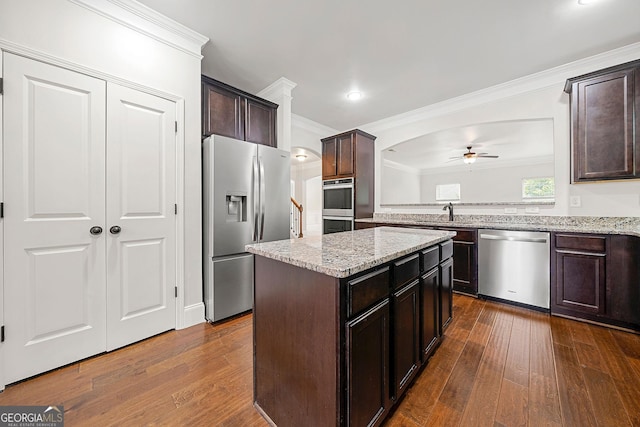 3865 Rifflepool Ct, Douglasville, GA 30135 - kitchen featuring appliances with stainless steel finishes, a ceiling fan, crown molding, dark wood-style floors, and dark brown cabinets