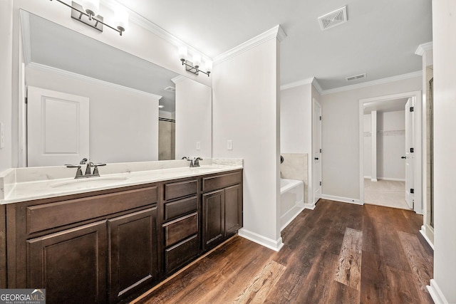 3865 Rifflepool Ct, Douglasville, GA 30135 - full bathroom with wood finished floors, double vanity, a garden tub, crown molding, and a walk in closet
