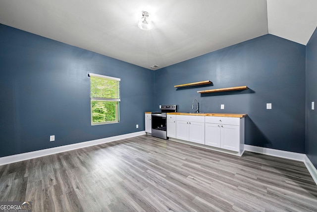 3865 Rifflepool Ct, Douglasville, GA 30135 - indoor wet bar featuring electric stove, light wood-style floors, and vaulted ceiling