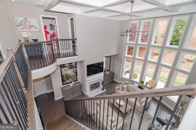 2720 Garonne Way, Cumming, GA 30041 - stairway featuring wood finished floors, plenty of natural light, coffered ceiling, beam ceiling, and a fireplace