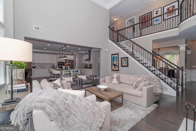 2720 Garonne Way, Cumming, GA 30041 - living room featuring a high ceiling, stairway, dark wood-style flooring, and ornate columns