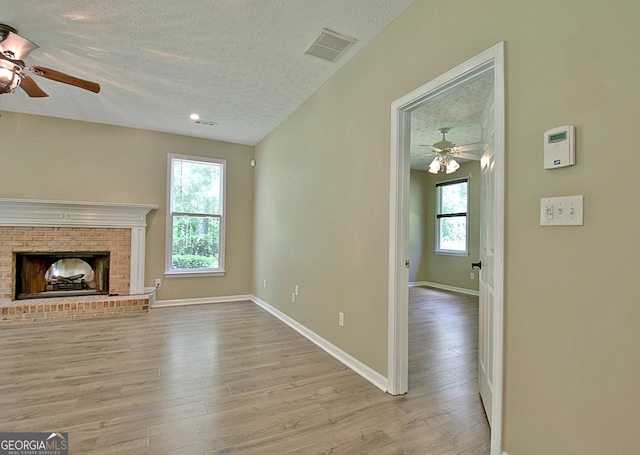 1709 Reese Rd, Sharpsburg, GA 30277 - unfurnished living room with ceiling fan, a textured ceiling, wood finished floors, and a fireplace