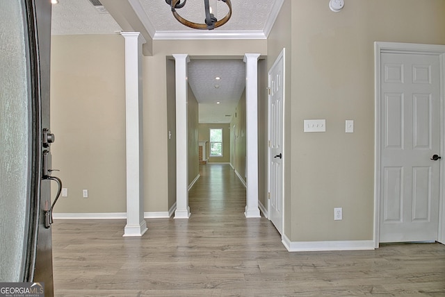 1709 Reese Rd, Sharpsburg, GA 30277 - entryway featuring decorative columns, light wood-type flooring, a textured ceiling, and crown molding