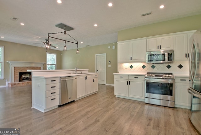 1709 Reese Rd, Sharpsburg, GA 30277 - kitchen featuring stainless steel appliances, ceiling fan, white cabinetry, decorative backsplash, and light wood-style flooring