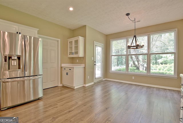 1709 Reese Rd, Sharpsburg, GA 30277 - kitchen featuring stainless steel fridge, light wood-style flooring, glass insert cabinets, a textured ceiling, and recessed lighting
