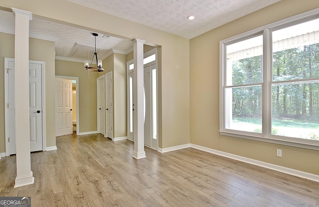1709 Reese Rd, Sharpsburg, GA 30277 - empty room with a textured ceiling, light wood-type flooring, crown molding, and a chandelier