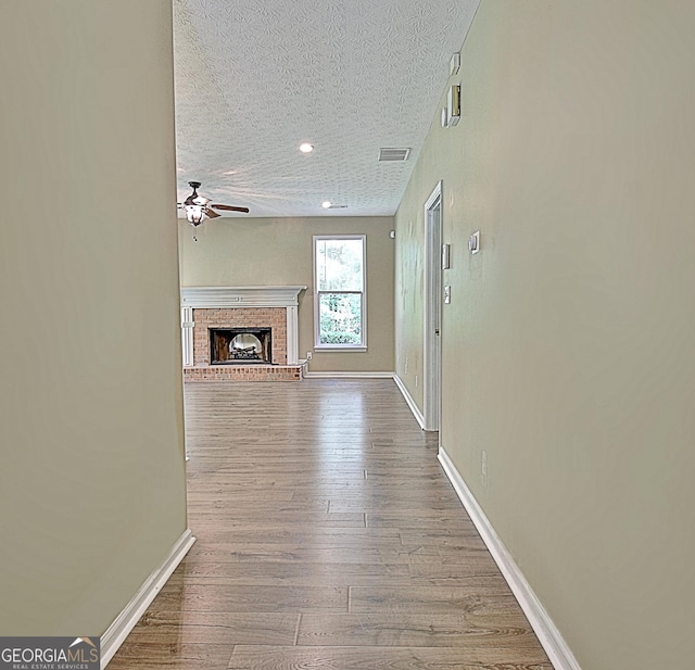 1709 Reese Rd, Sharpsburg, GA 30277 - unfurnished living room with ceiling fan, a textured ceiling, wood finished floors, a fireplace, and recessed lighting