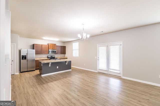 243 Flowing Meadows Dr, Kathleen, GA 31047 - kitchen featuring stainless steel appliances, a chandelier, a kitchen breakfast bar, light wood-type flooring, and light countertops