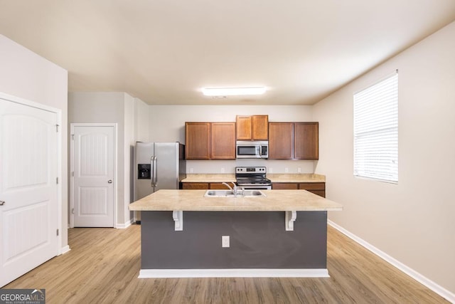 243 Flowing Meadows Dr, Kathleen, GA 31047 - kitchen featuring appliances with stainless steel finishes, light countertops, a kitchen breakfast bar, and light wood finished floors